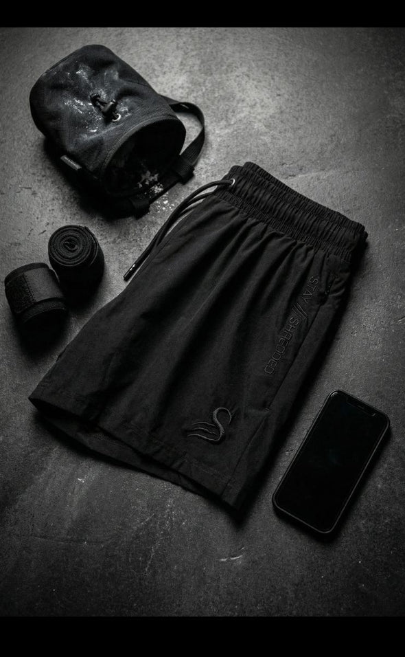 Leg day shorts for men Australia - black gym shorts flat lay with training essentials including wraps and gym bag for serious lifters