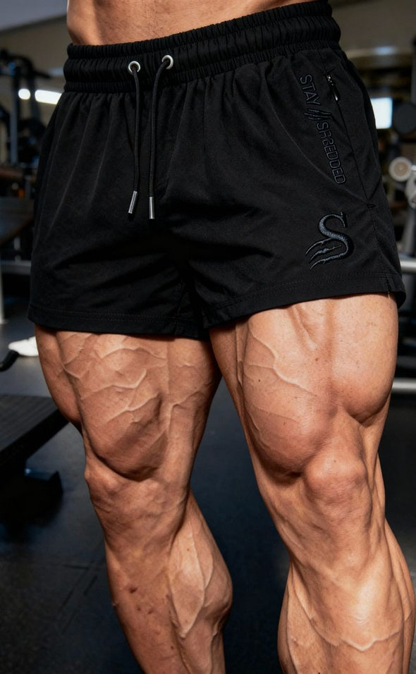 Mens gym shorts Australia showing developed quads - black leg day shorts for Australian lifters with visible muscle definition and Stay Shredded S logo